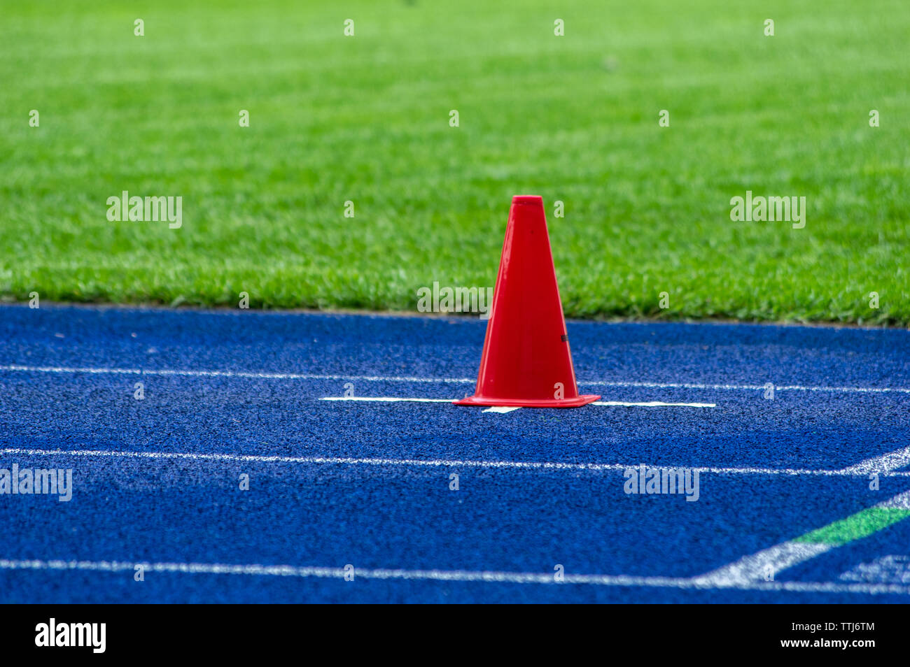 Cône de trafic sur la piste en tartan bleu dans le stade Banque D'Images