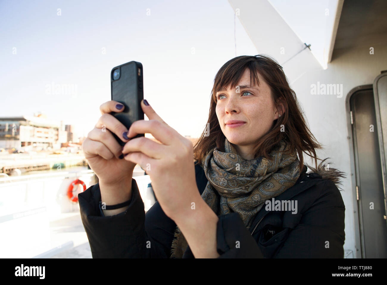 Femme photographiant via téléphone portable en voyage d'engins à passagers à Banque D'Images