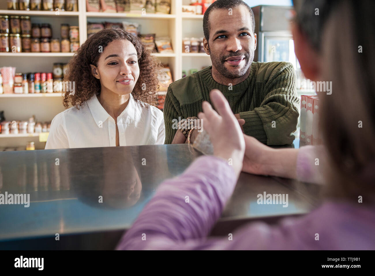 Les clients à la recherche de propriétaire alors que l'article en magasin Banque D'Images