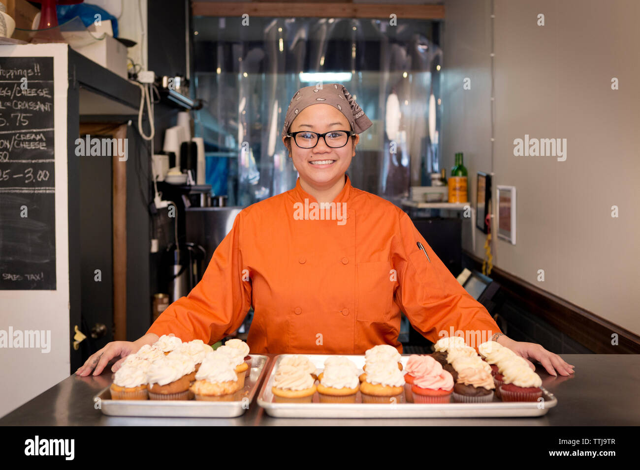 Portrait de femme debout avec cupcakes par store Banque D'Images