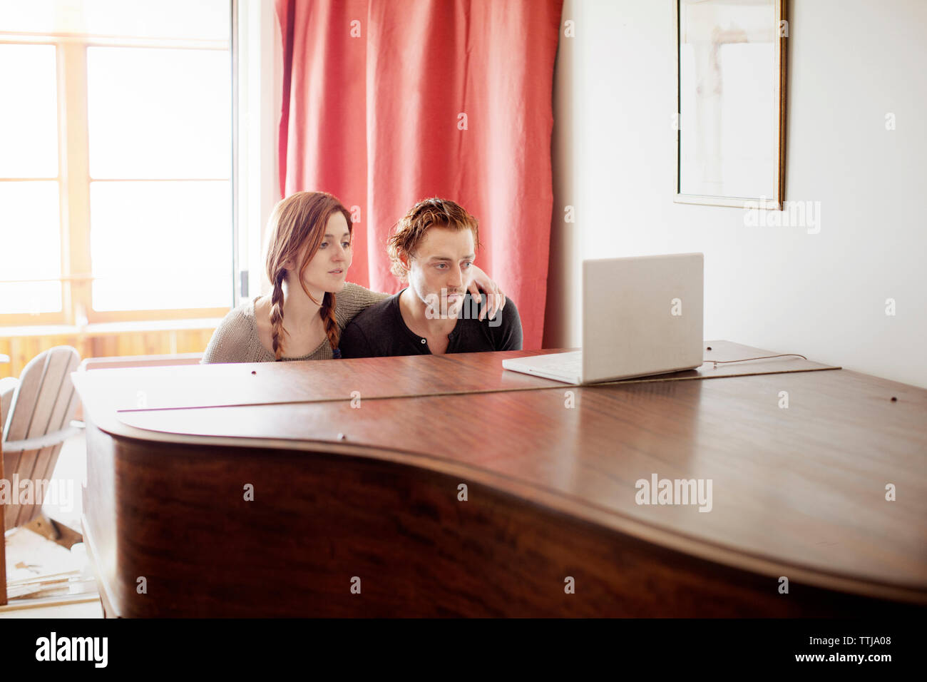 Couple looking at laptop computer at home Banque D'Images