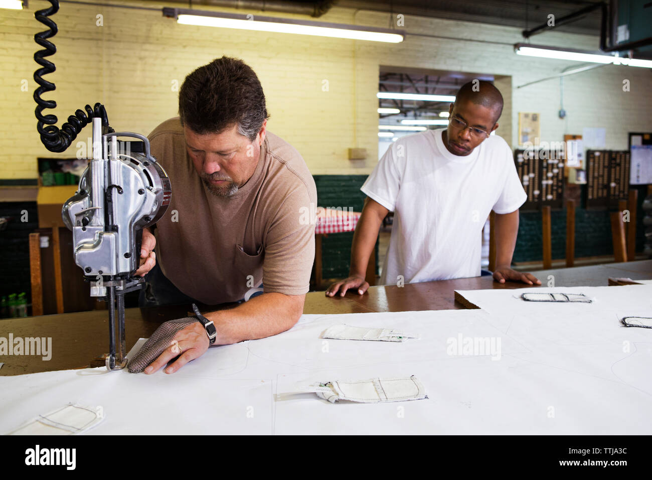 ouvriers utilisant des machines en usine Banque D'Images