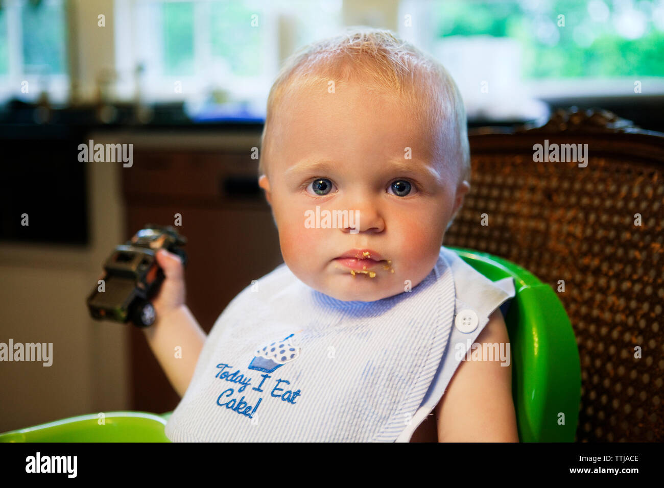 Portrait de bébé garçon assis sur la chaise haute à la maison Banque D'Images
