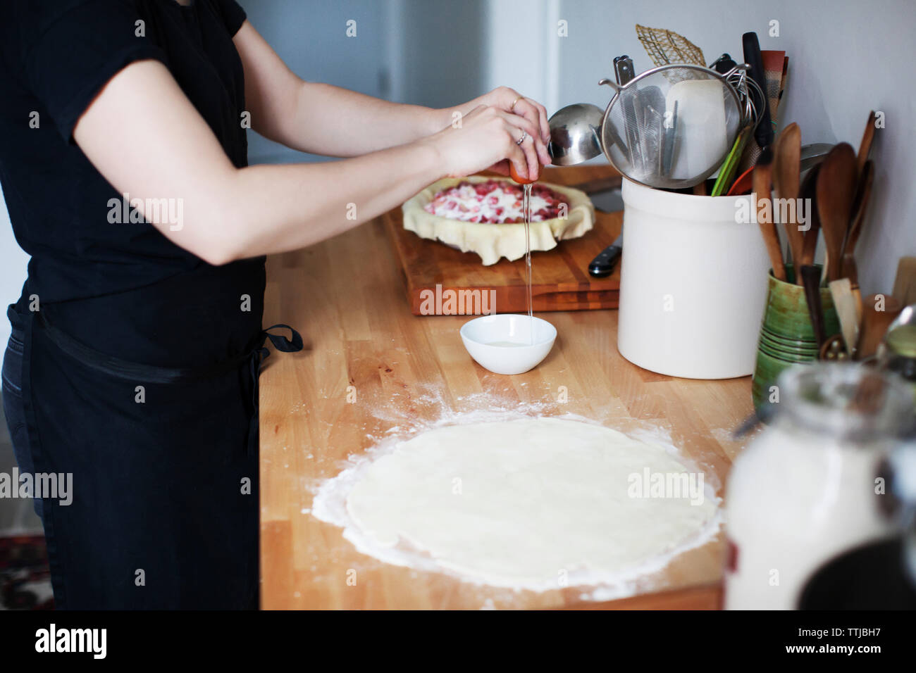 Midsection of woman breaking egg in bowl Banque D'Images