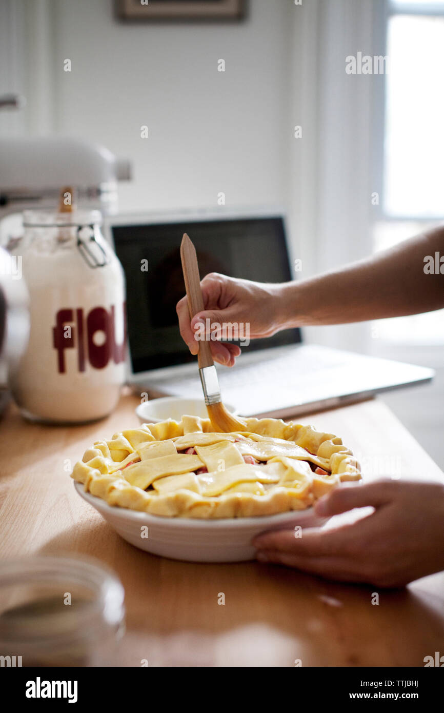 Portrait de mains d'oeuf de brossage sur pie Banque D'Images