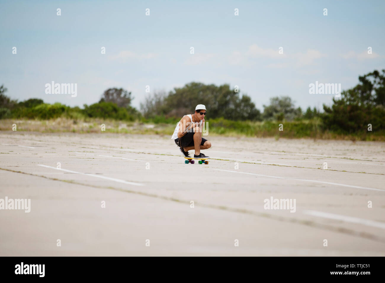 Man performing stunt sur planche sur le terrain contre le ciel Banque D'Images