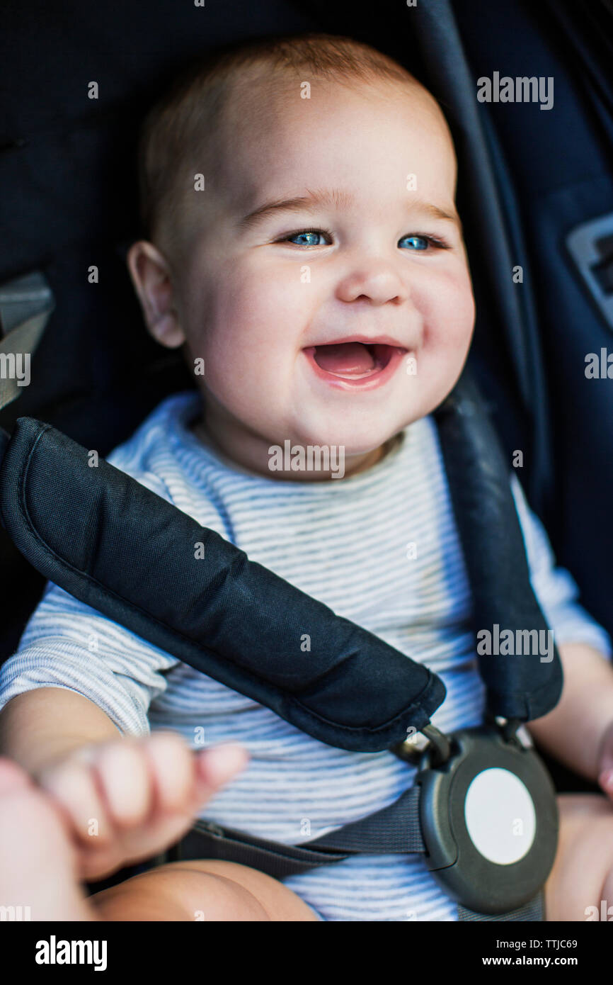Cute boy laughing while sitting in poussette de bébé Banque D'Images