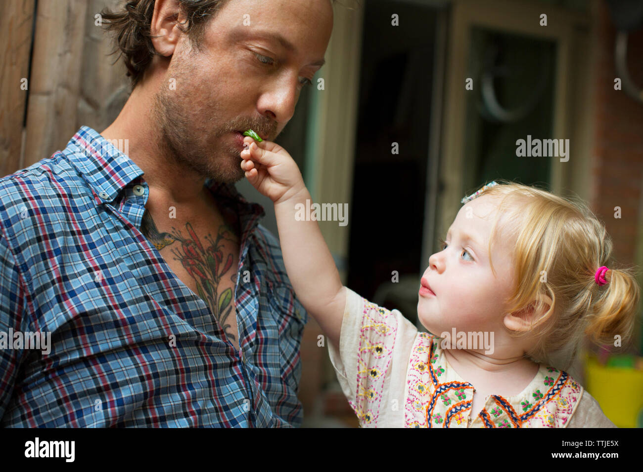 Alimentation bébé fille père à la maison Banque D'Images