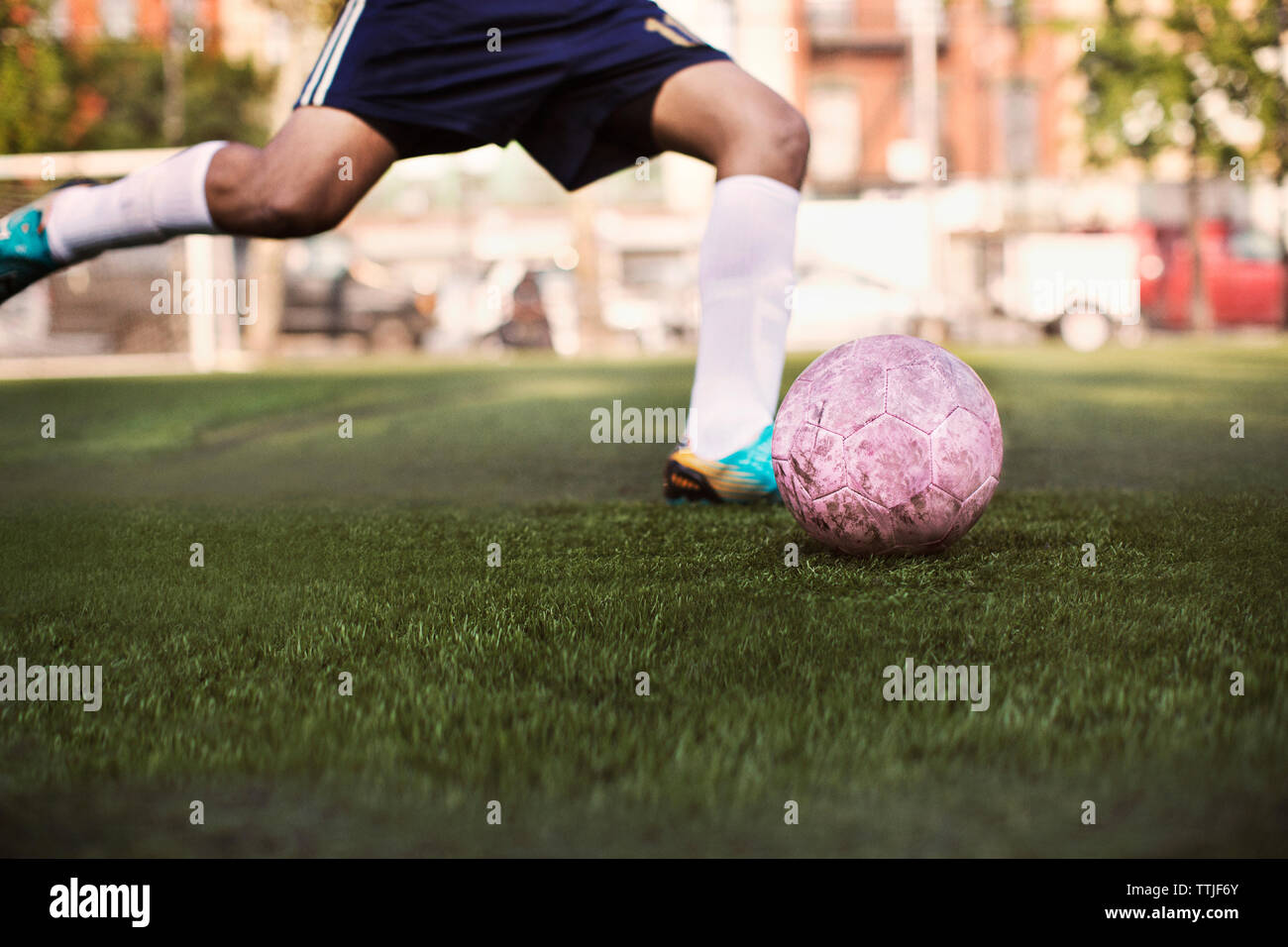 La section basse de kicking ball athlète au terrain de soccer Banque D'Images