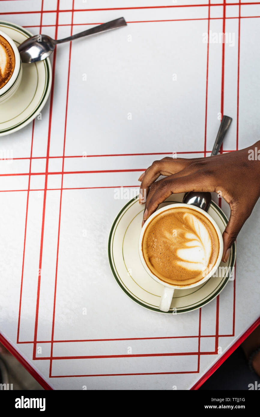 Portrait of hand holding cappuccino au sidewalk cafe Banque D'Images Portrait of hand holding cappuccino au sidewalk cafe Banque D'Images