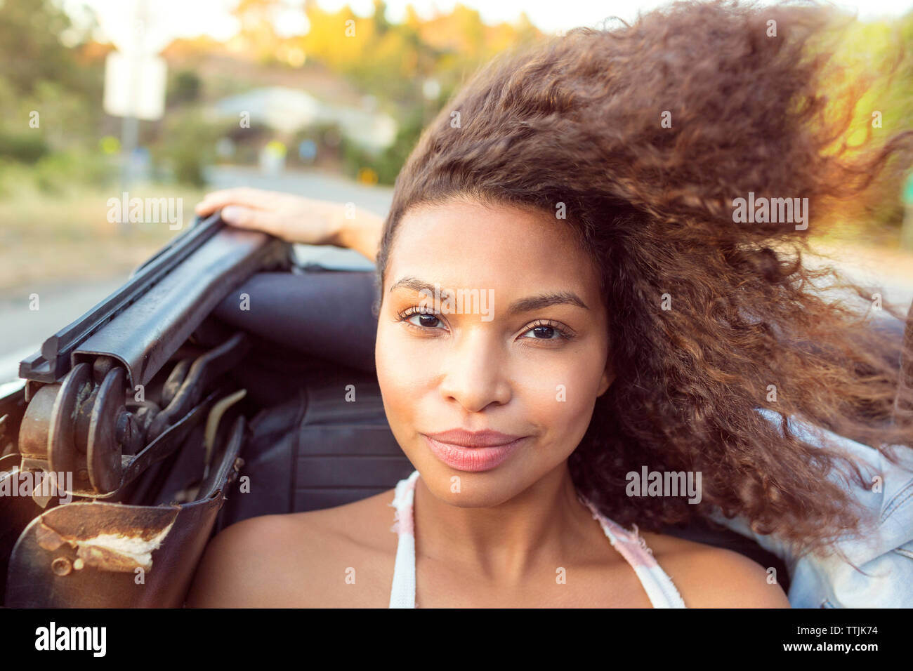 Portrait of smiling woman sitting in convertible car Banque D'Images