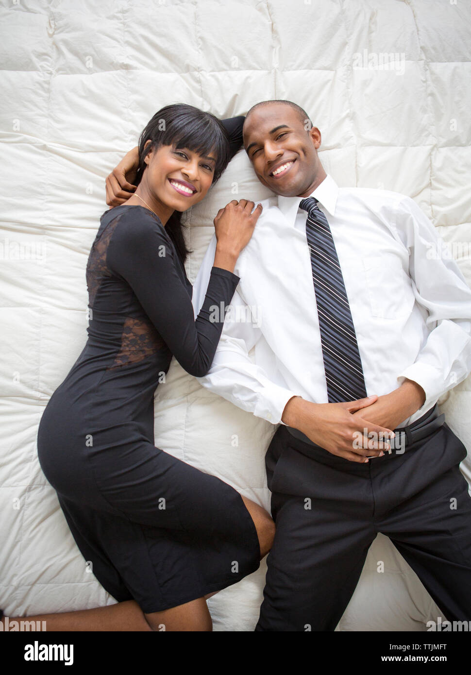 Portrait of smiling couple lying on bed Banque D'Images
