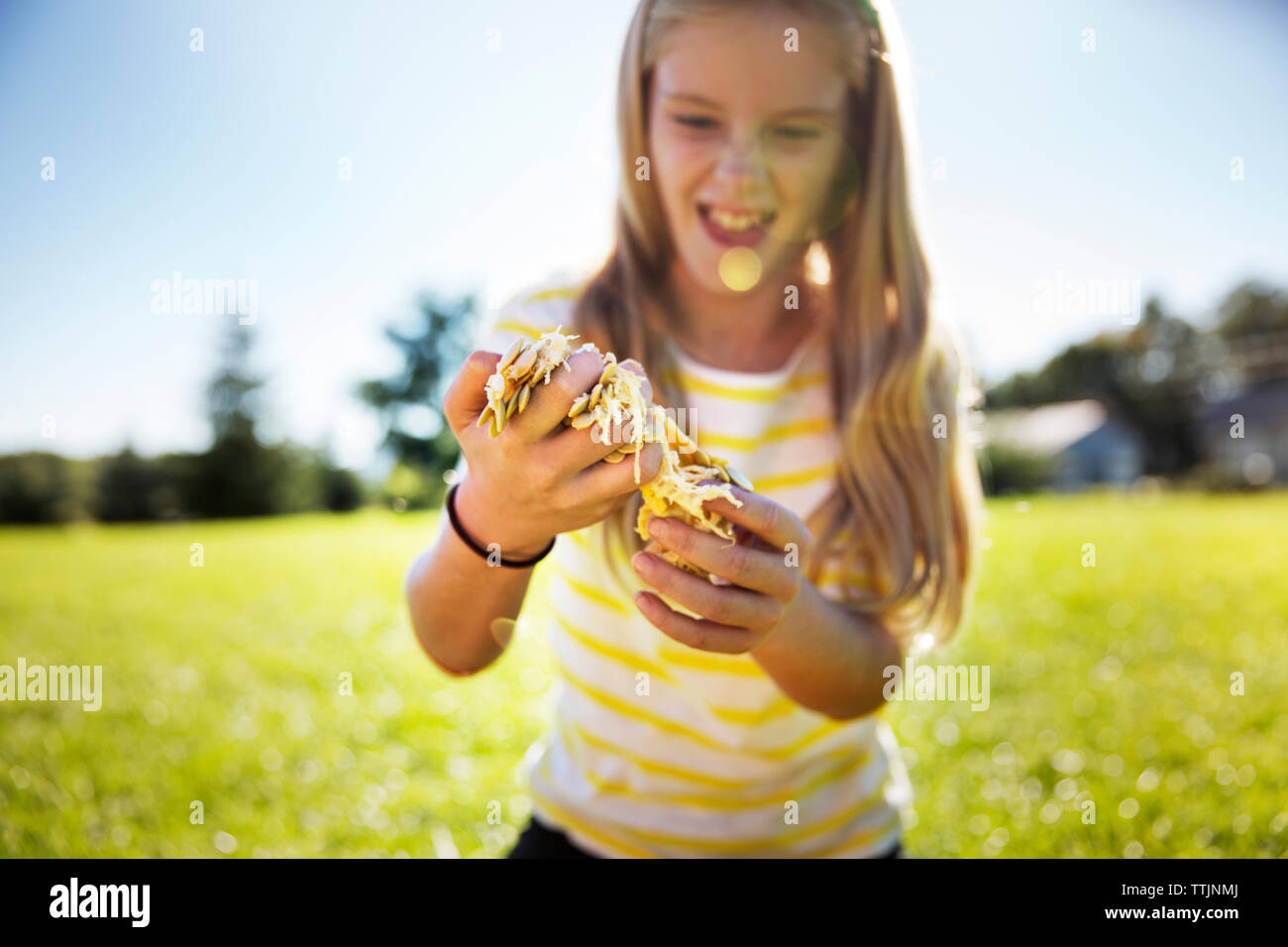 Happy girl holding pumpkin pulpe sur terrain au cours de l'été Banque D'Images