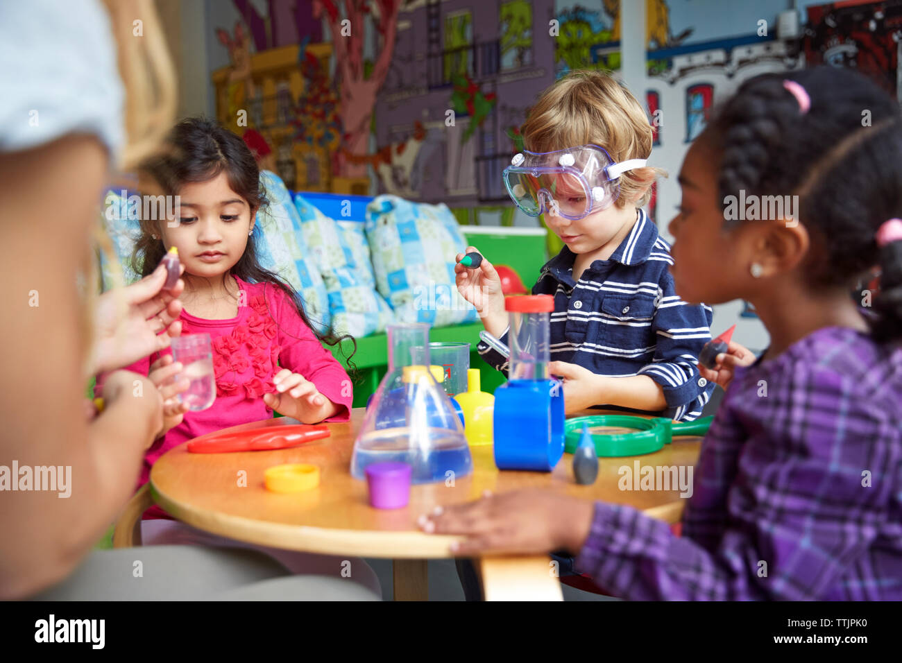 Les enfants faire de la science experiment at table in preschool Banque D'Images