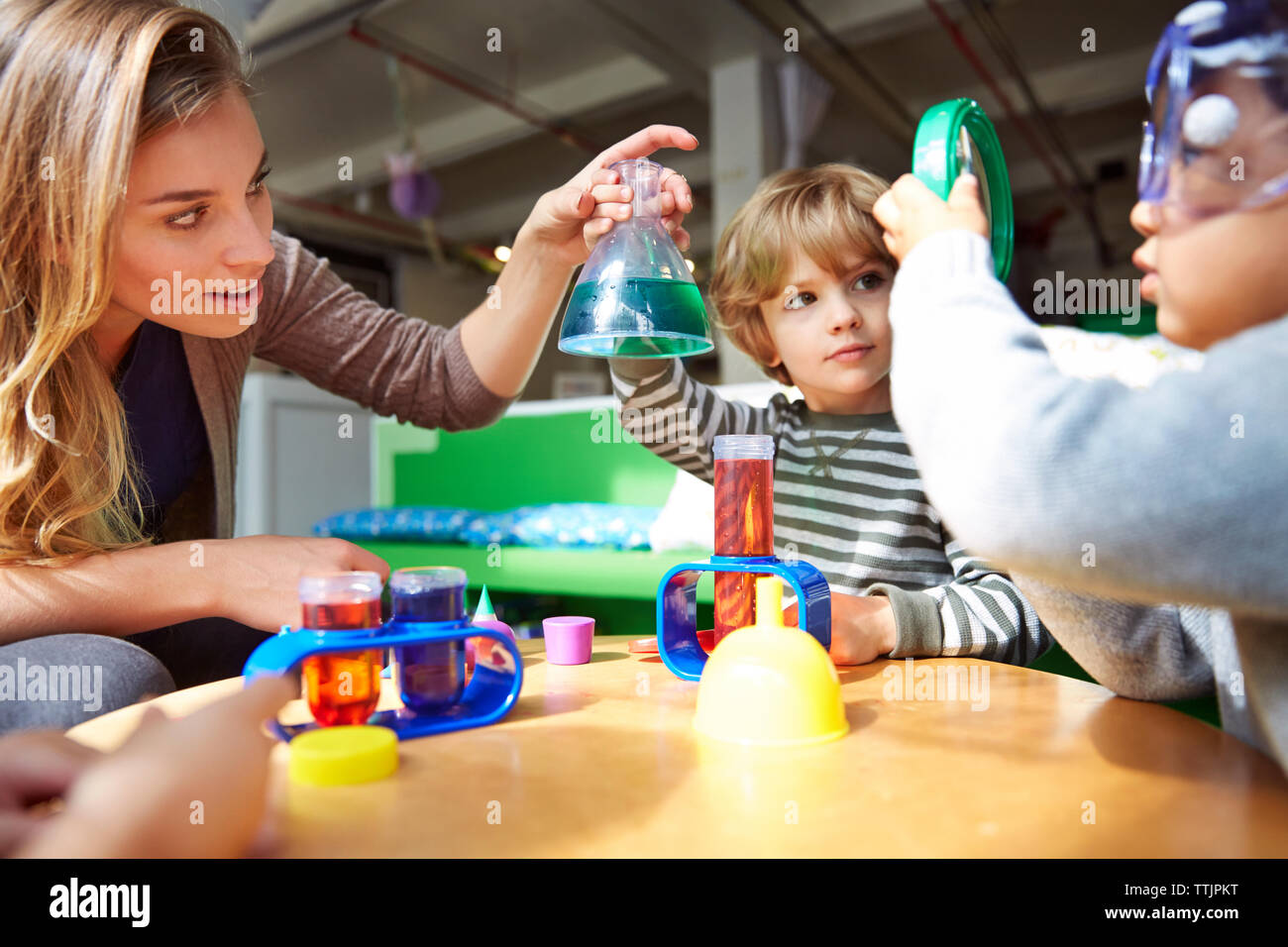 L'enseignant et les étudiants en science experiment at table in preschool Banque D'Images