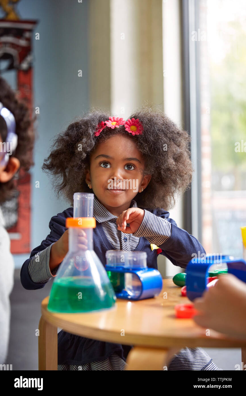 Surpris girl looking away pendant expérience scientifique dans l'enseignement préscolaire Banque D'Images