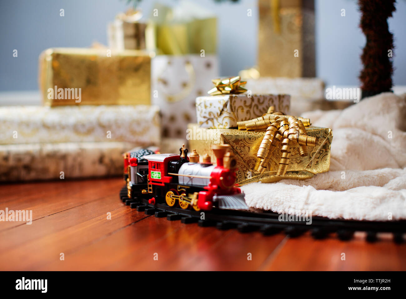 Train miniature et coffrets cadeaux sur plancher de bois franc Banque D'Images