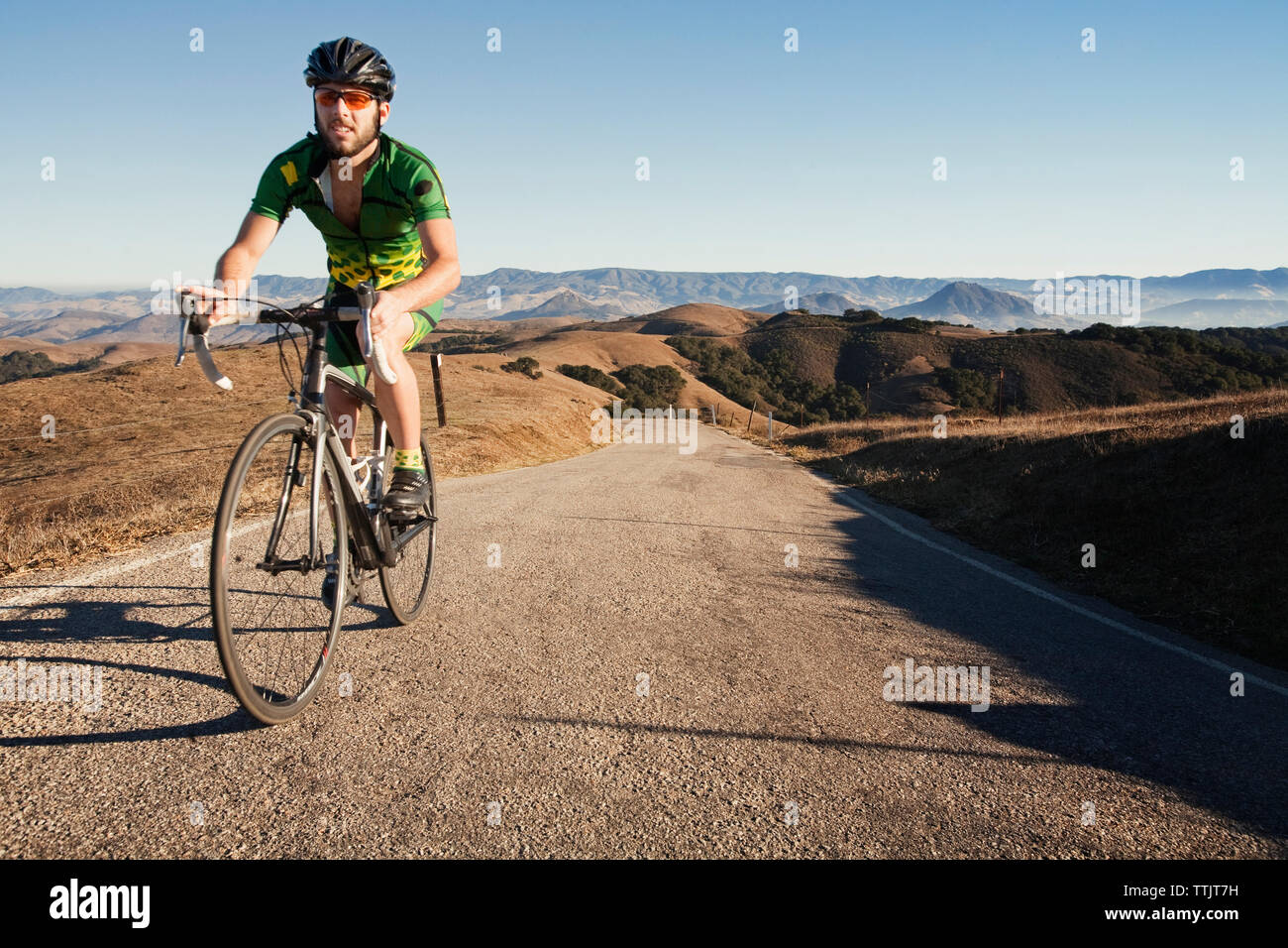 Man riding bicycle sur gravier contre ciel clair Banque D'Images