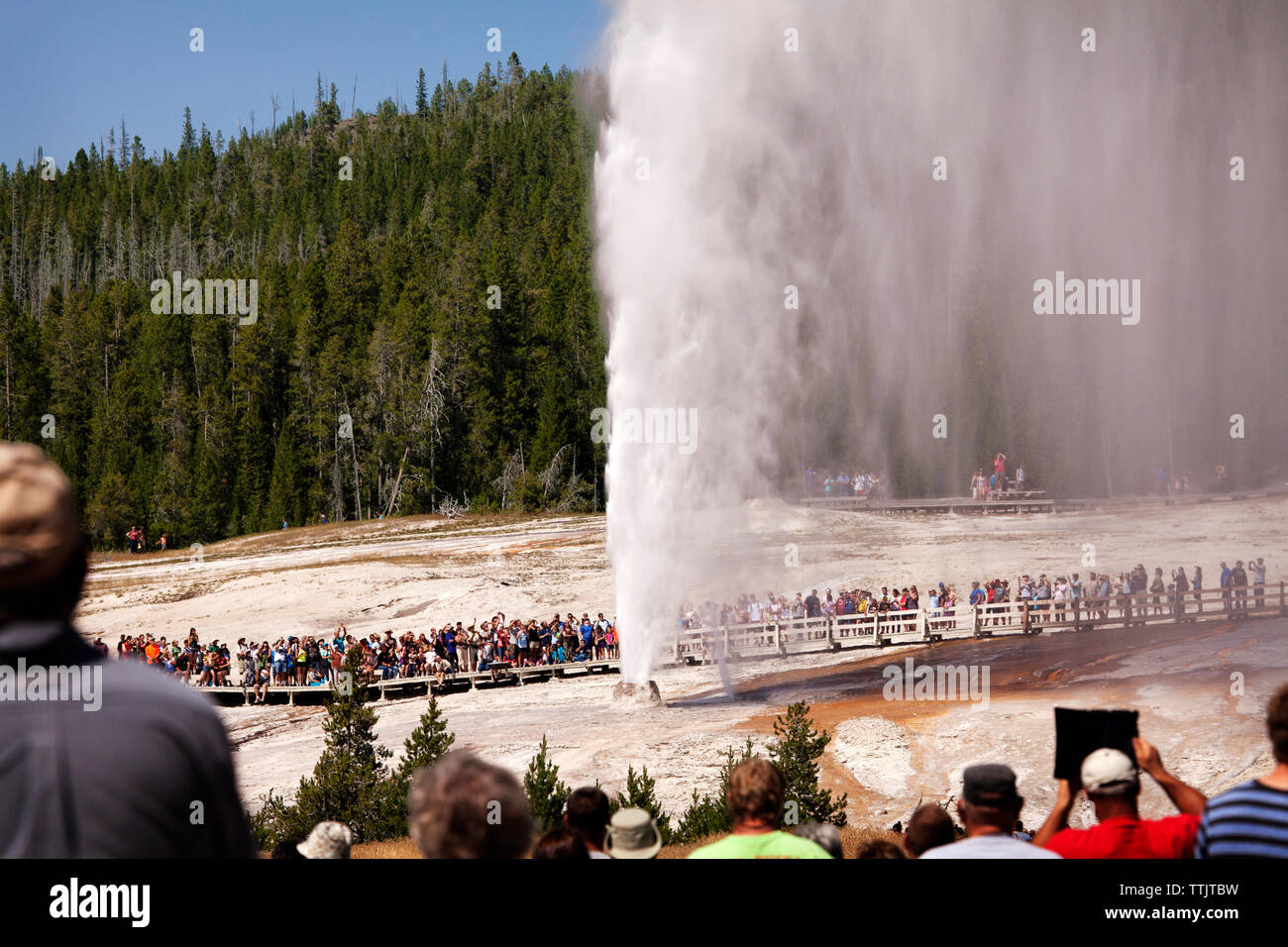 Les touristes visitant Old Faithful Geyser Yellowstone National Park Banque D'Images