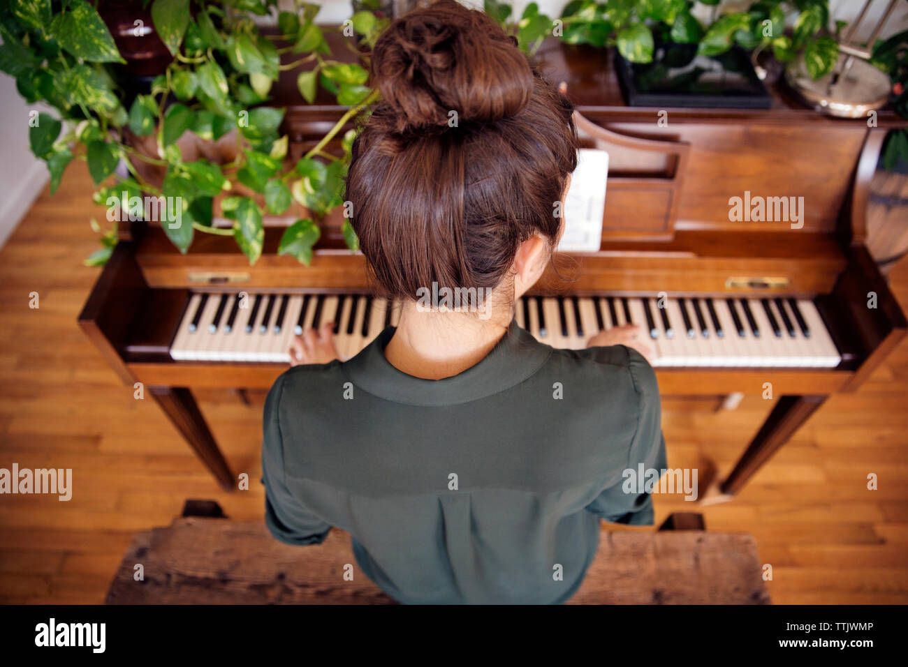 Portrait de femme jouant du piano à la maison Banque D'Images