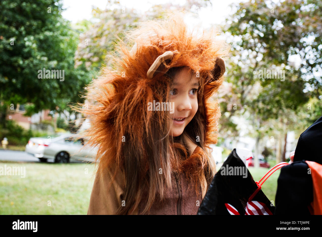 Cheerful girl en costume Halloween debout sur tour ou traitement au cours de la voie Banque D'Images