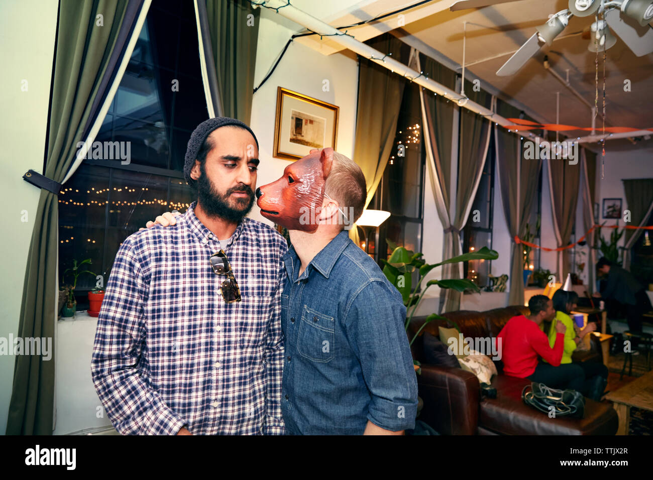 Agacé man wearing mask ami pendant party Banque D'Images