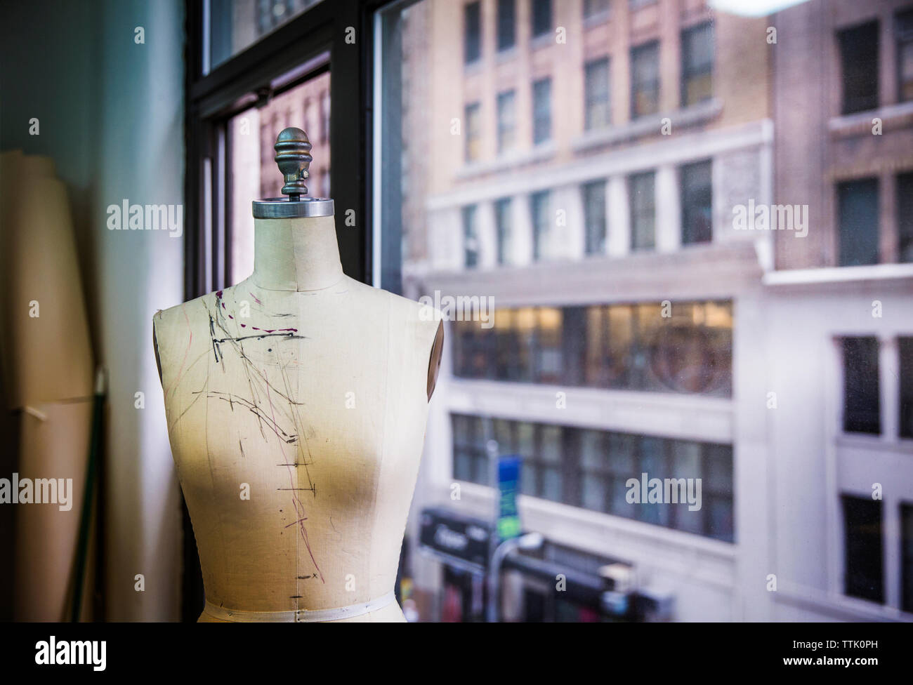 Modèle de couturière, par la fenêtre en verre au design studio Banque D'Images