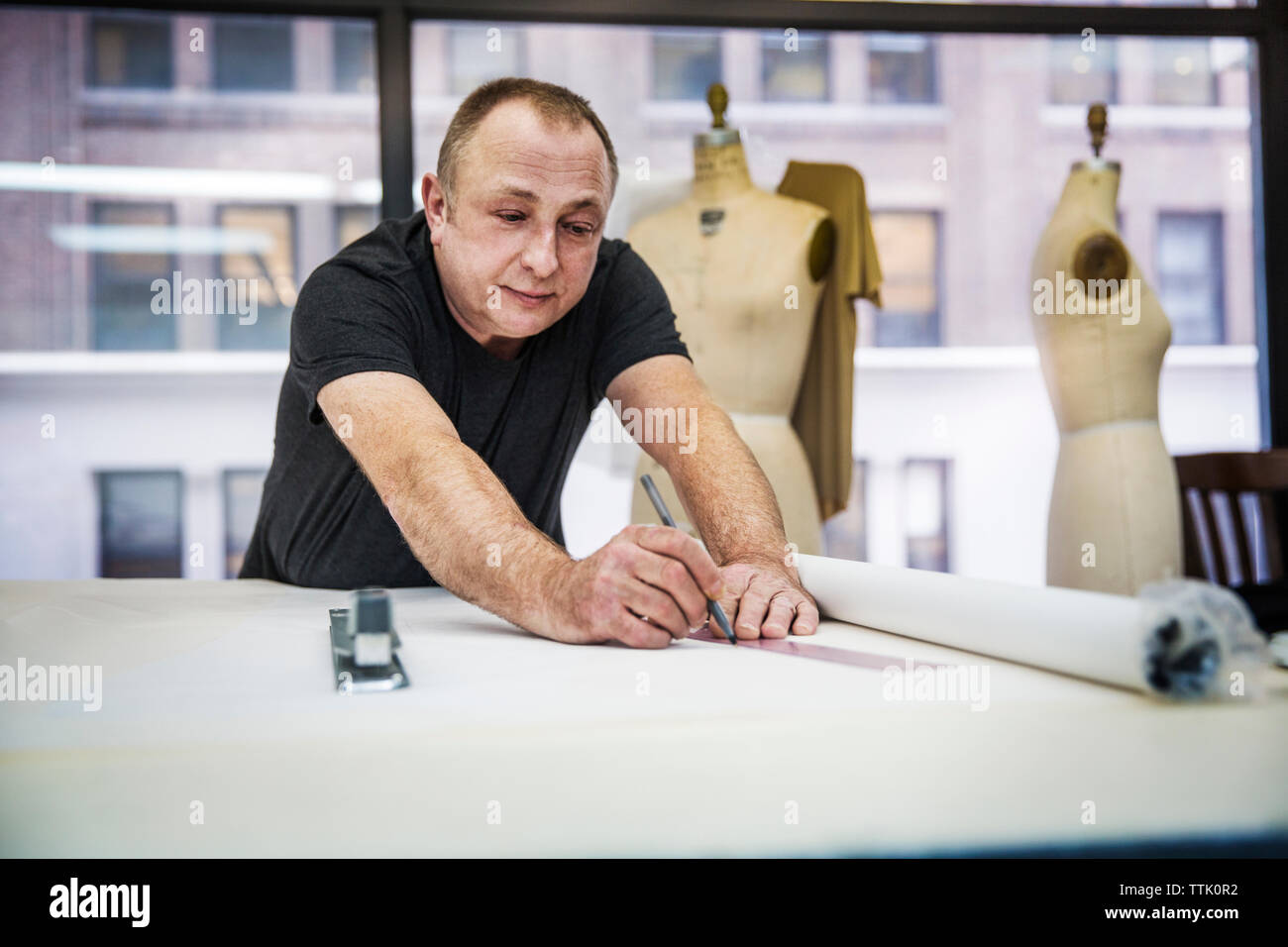 Fashion designer working at table in design studio Banque D'Images