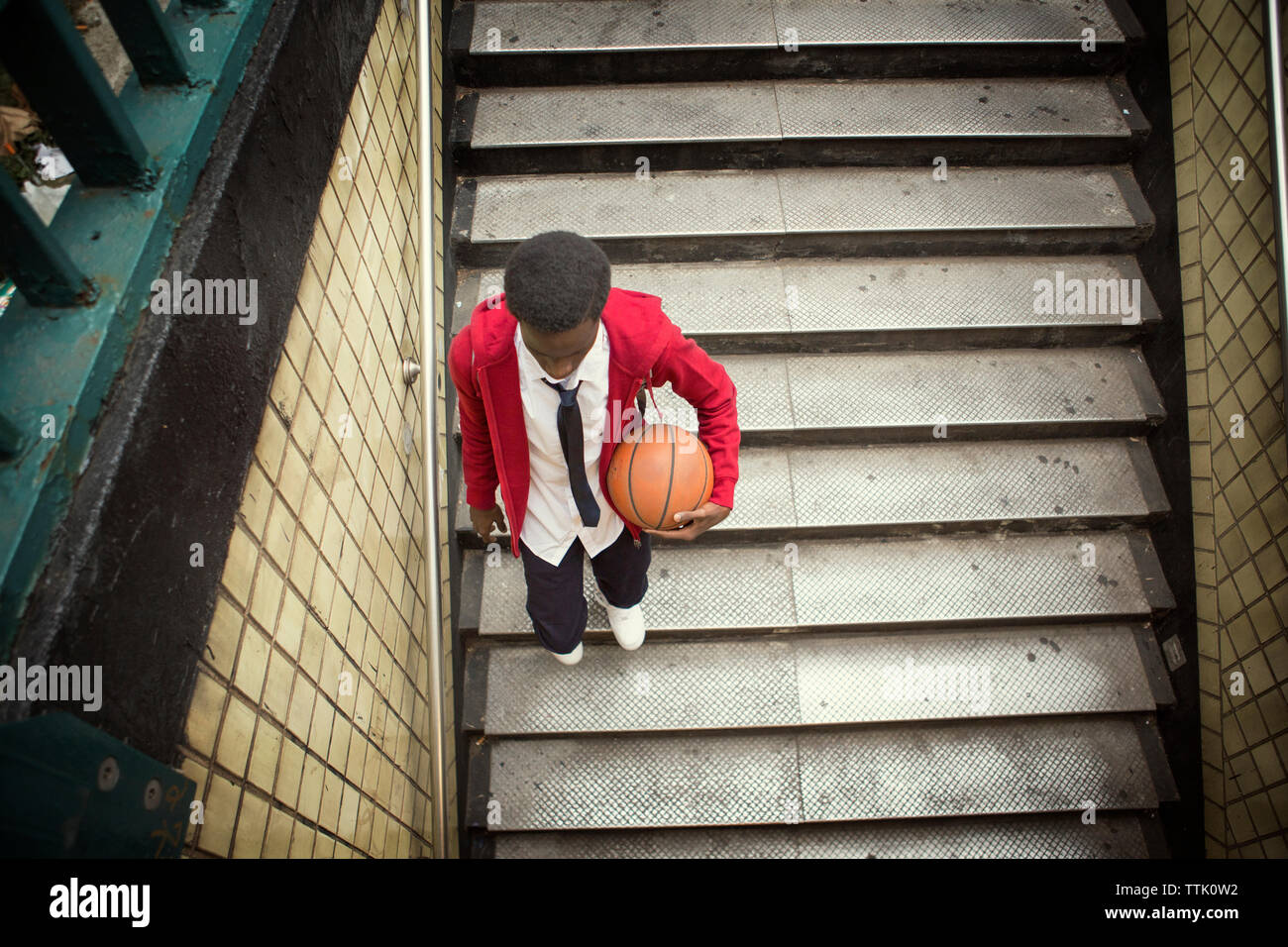 High angle view of student holding basketball walking down steps Banque D'Images