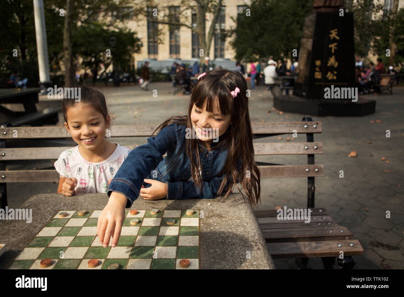 Father playing checkers game in park Banque D'Images