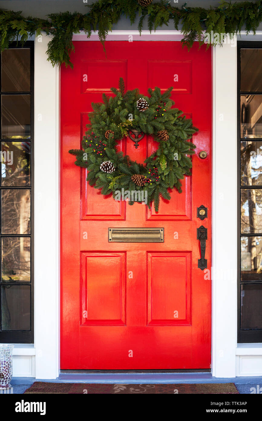 couronne de noël accrochée à la porte rouge Banque D'Images