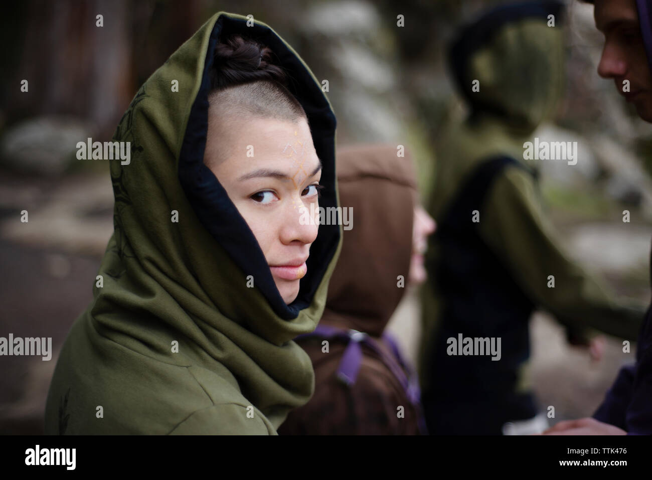 Portrait of woman wearing hooded shirt debout avec des amis à hanging rock Banque D'Images