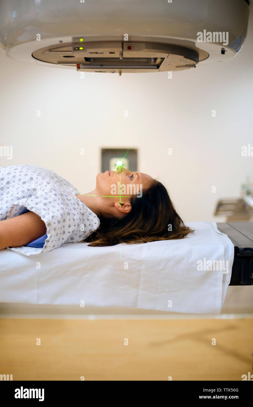 Vue latérale du female patient lying sous machine à rayons X Banque D'Images