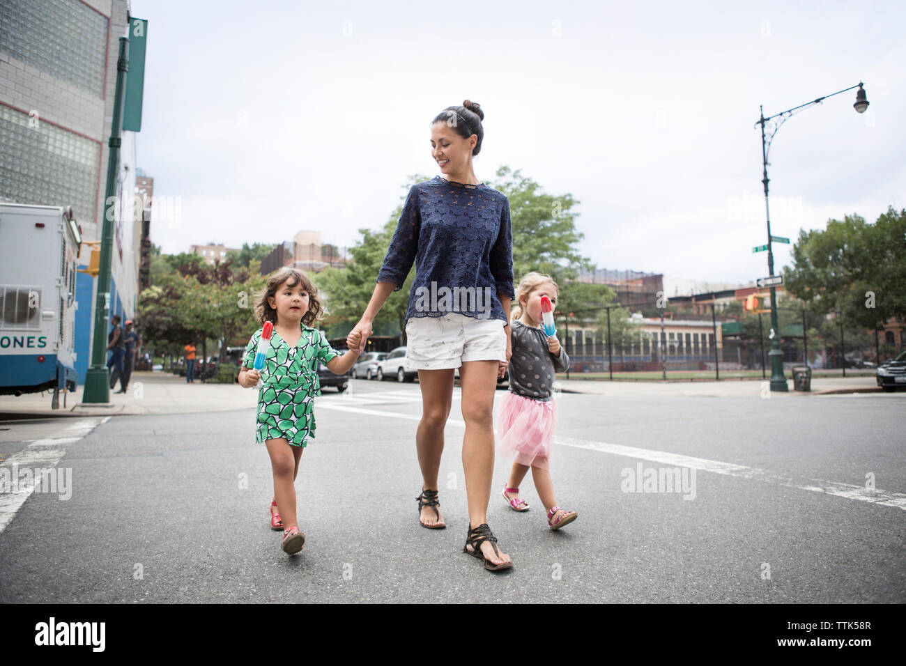 Pour manger des glaces en marchant avec la mère sur la rue Banque D'Images