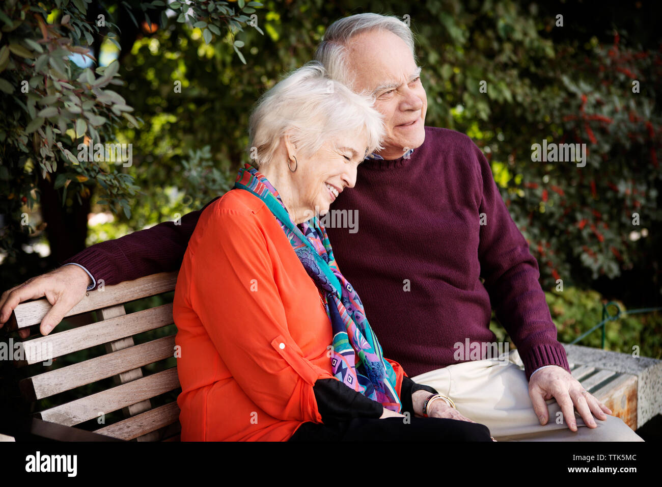 Happy senior couple sitting on park bench Banque D'Images