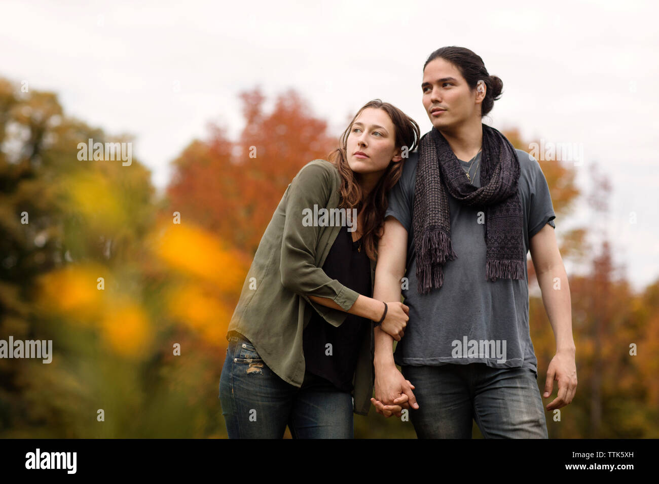 Couple Holding Hands et à l'écart lors de la marche sur terrain Banque D'Images