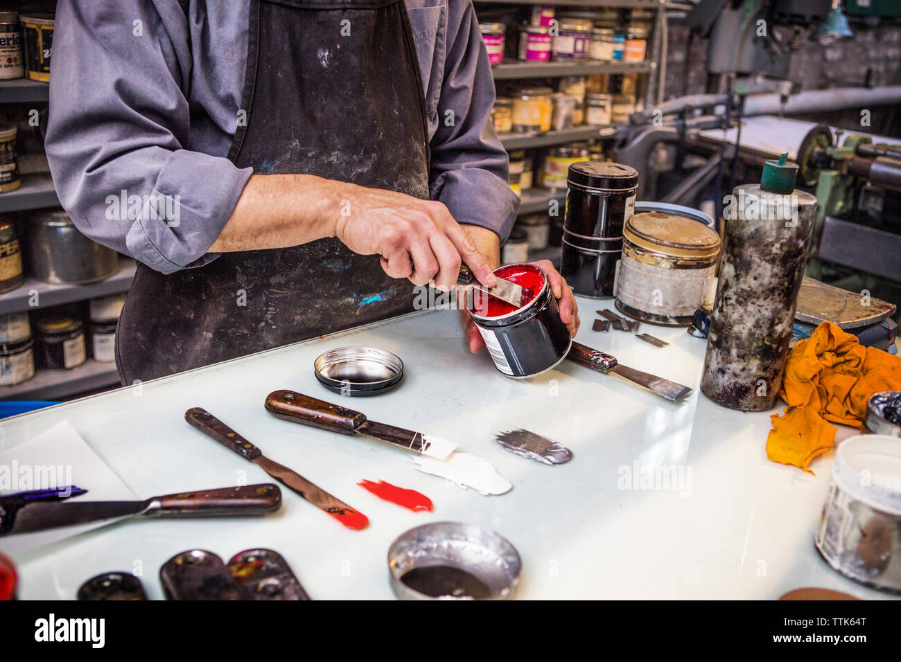 Portrait de l'homme dépose la peinture de pouvez avec de l'encre sur la table couteau Banque D'Images