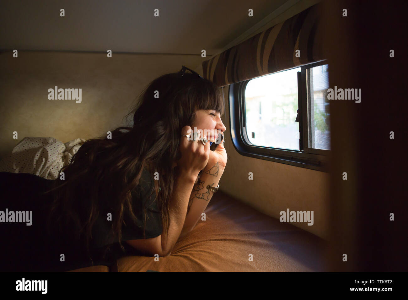 Happy Woman talking on smart phone en voyageant dans le camping-car Banque D'Images