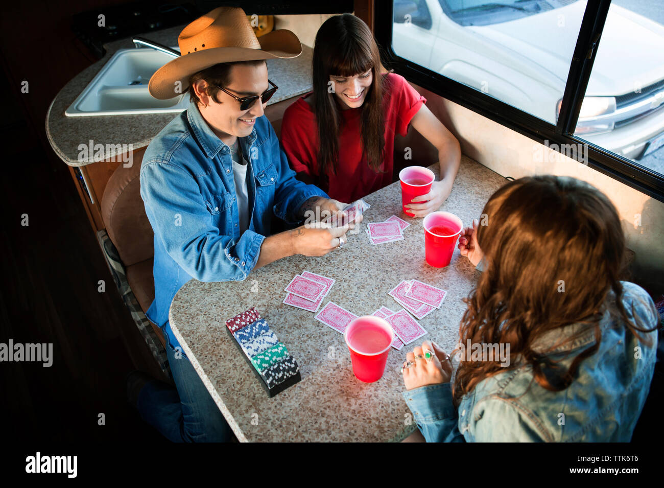 Angel haut afficher d'amis jouent aux cartes à la table lors d'un voyage en camping-van Banque D'Images