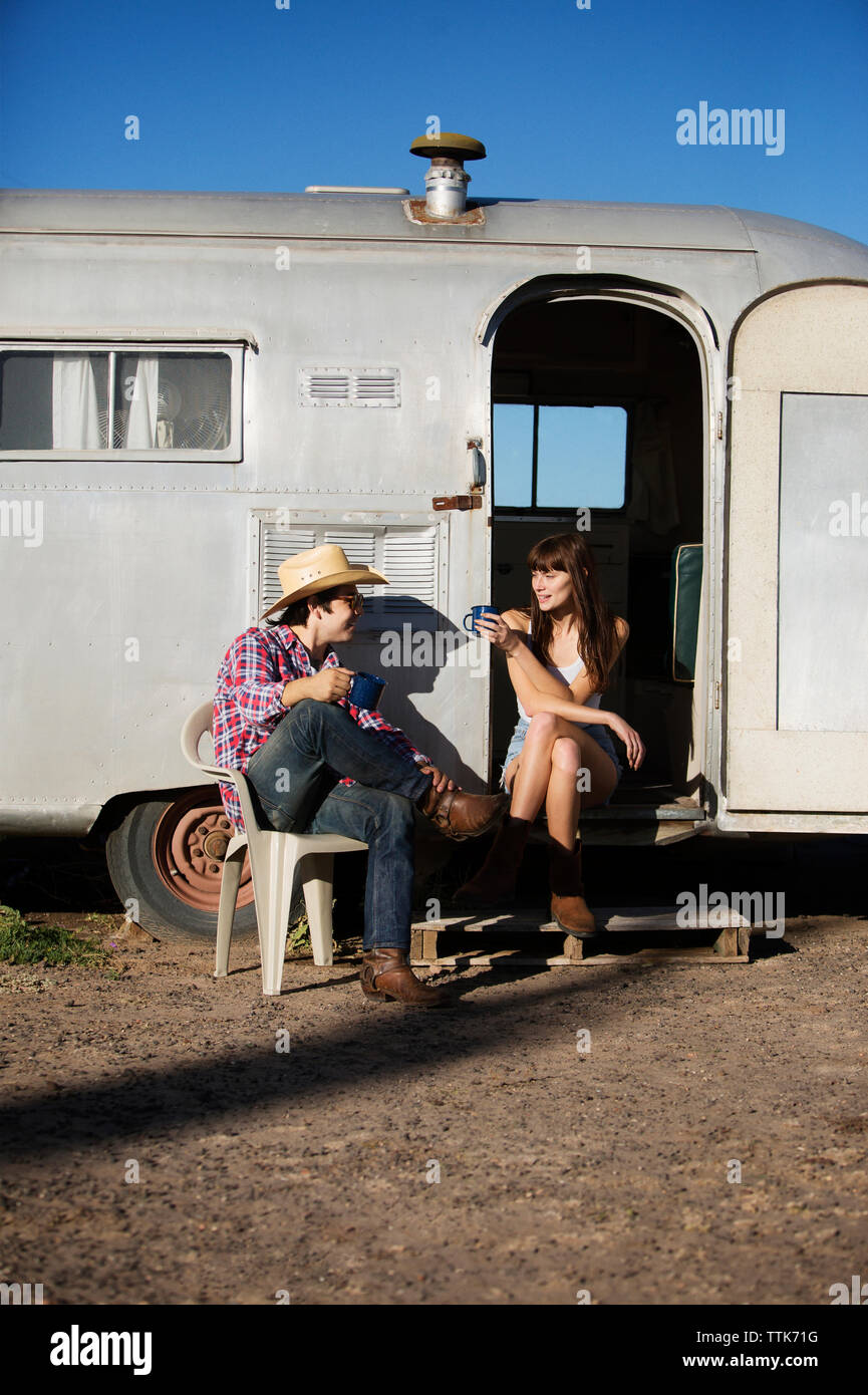 Couple having coffee alors qu'il était assis à l'extérieur le camping-car Banque D'Images Couple having coffee alors qu'il était assis à l'extérieur le camping-car Banque D'Images