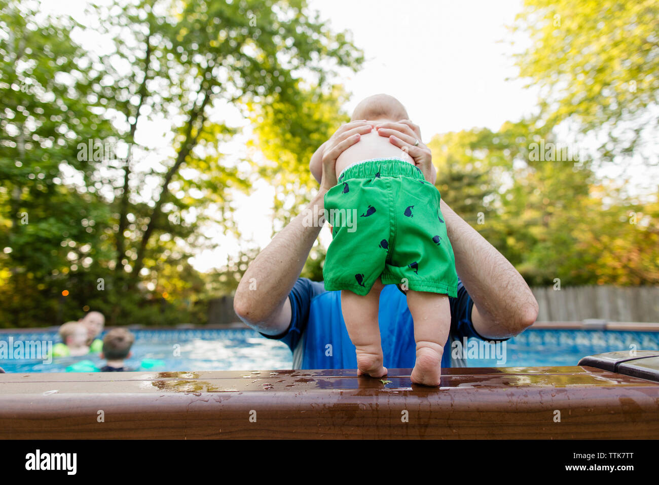 Père Fils torse nu tenant in swimming pool Photo Stock Alamy