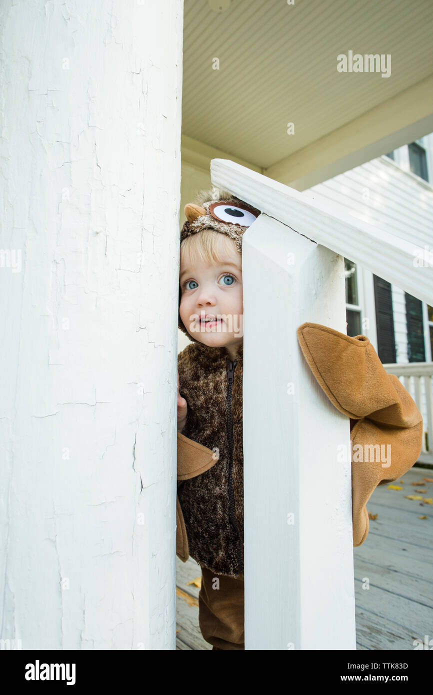 Curieux habillé bébé garçon regarde à travers garde-fous à l'Halloween Banque D'Images