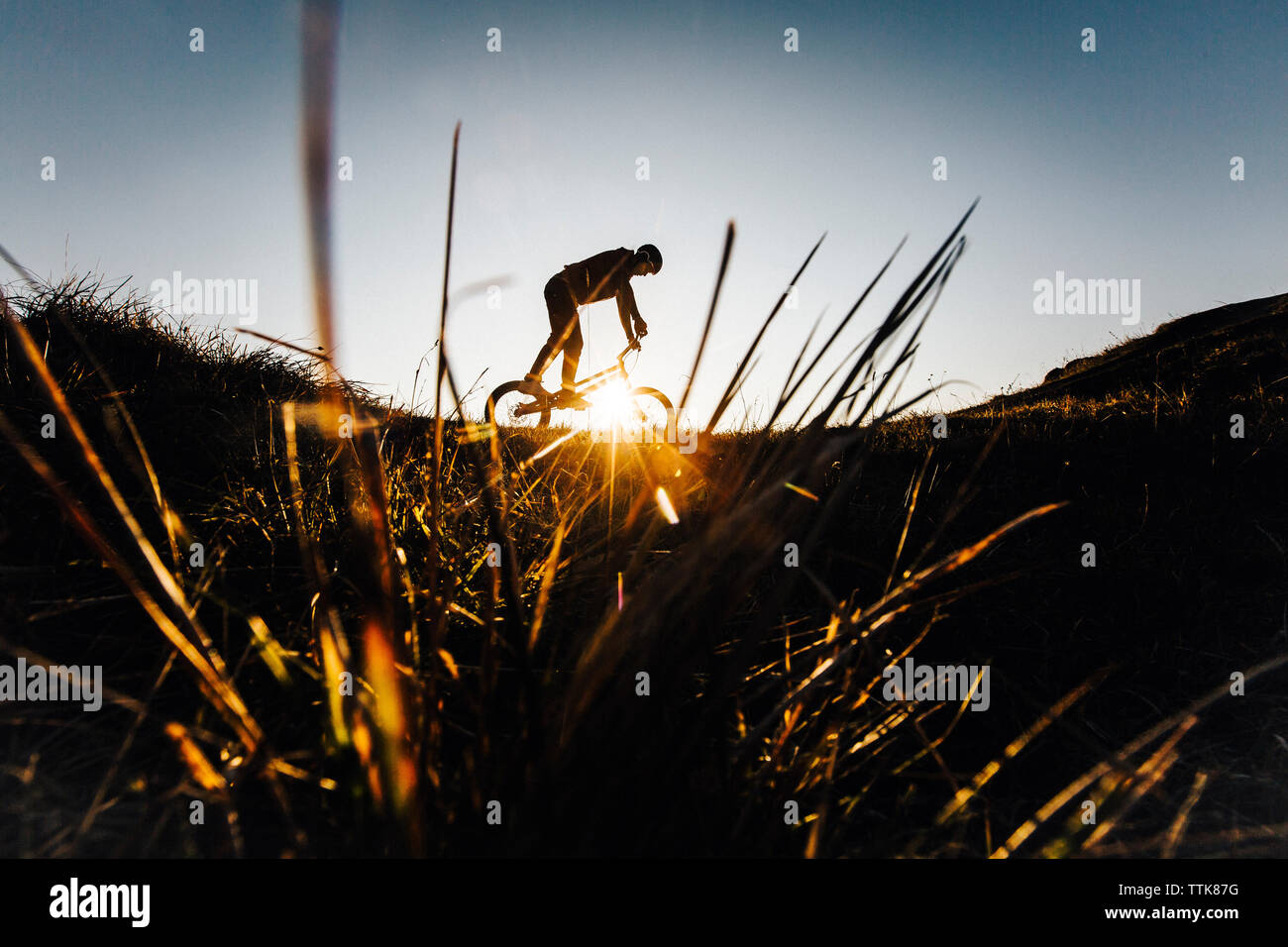Jeune homme est à cheval sur un vélo lors d'un lever du soleil. La Slovaquie Banque D'Images