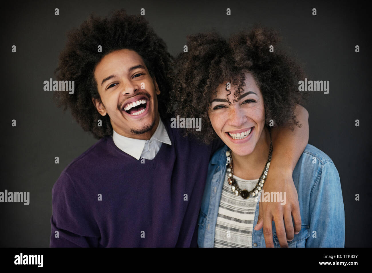 Portrait of happy businessman standing bras autour de collègue sur fond noir Banque D'Images