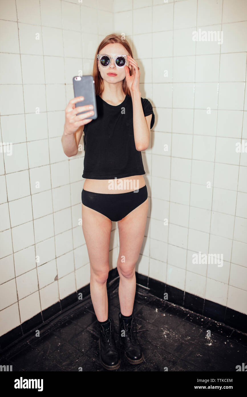 Femme avec téléphone en verres sur mur carrelé selfies antécédents, Banque D'Images