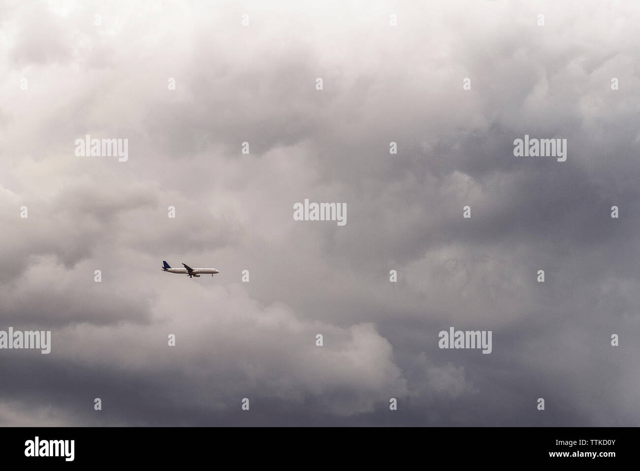 Low angle view of airplane flying in ciel nuageux Banque D'Images