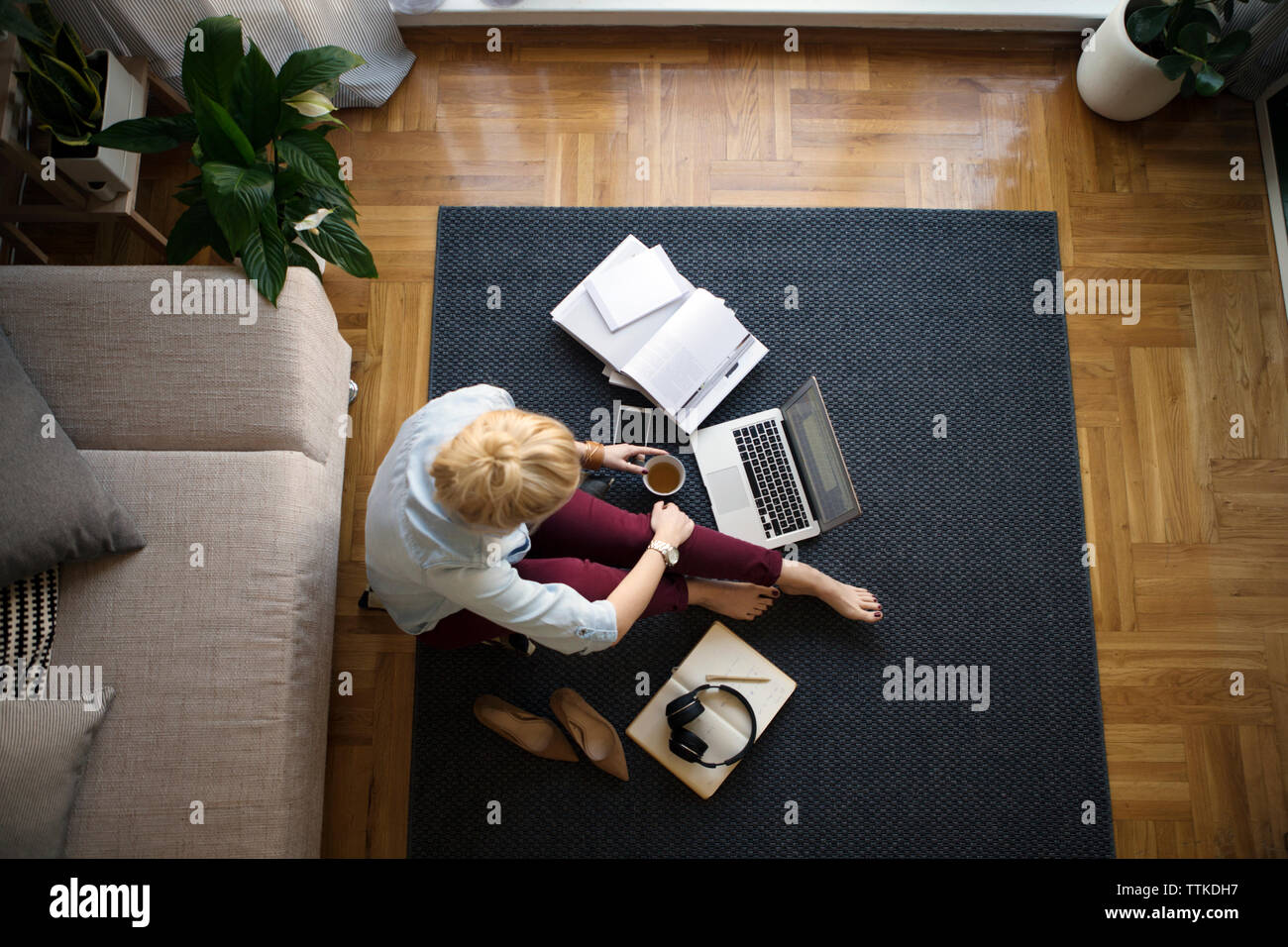 Vue de dessus de femme travaillant sur le plancher dans la salle de séjour Banque D'Images
