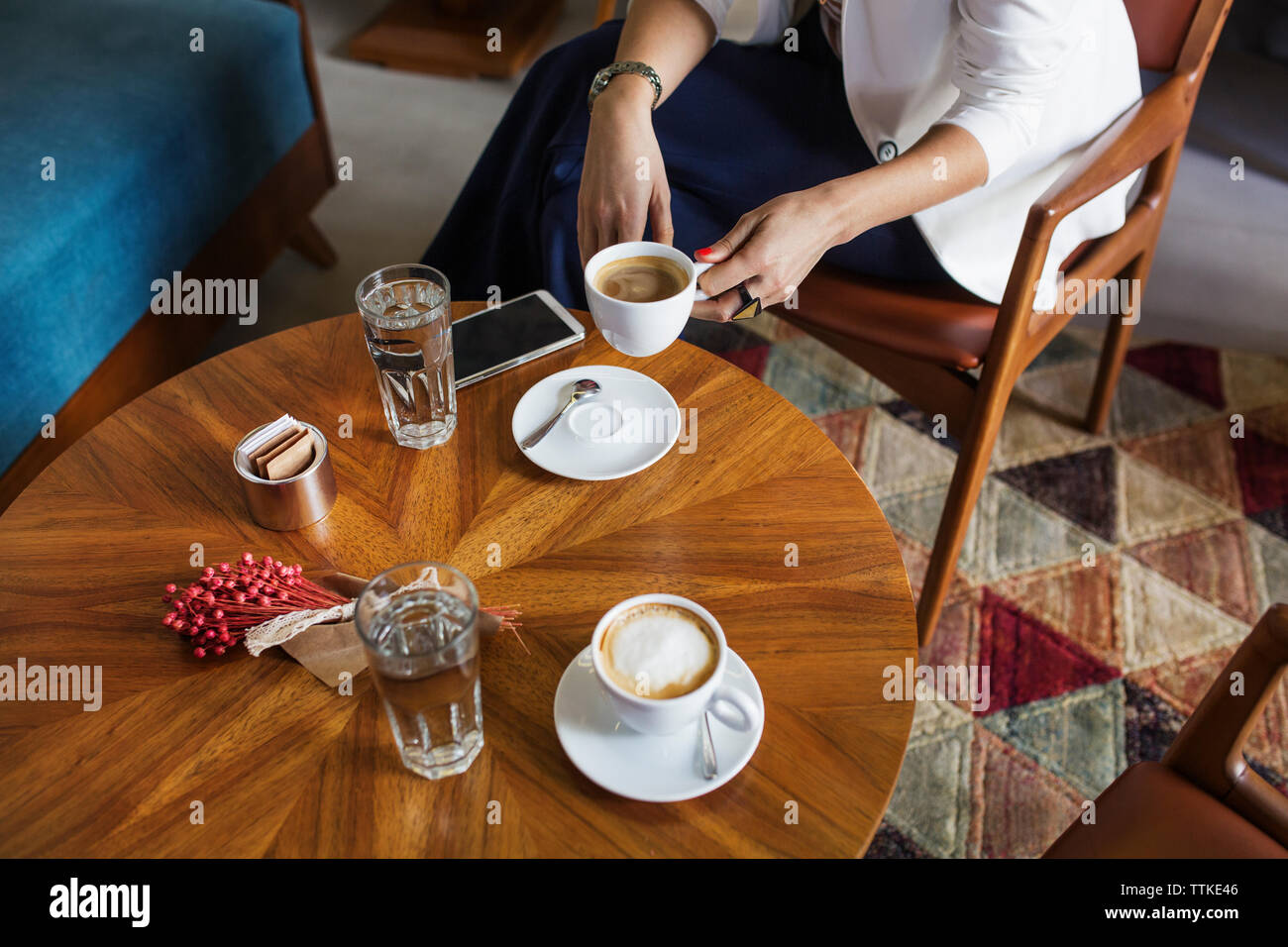 Portrait of businesswoman holding Coffee cup à table dans le lobby de l'hôtel Banque D'Images Portrait of businesswoman holding Coffee cup à table dans le lobby de l'hôtel Banque D'Images