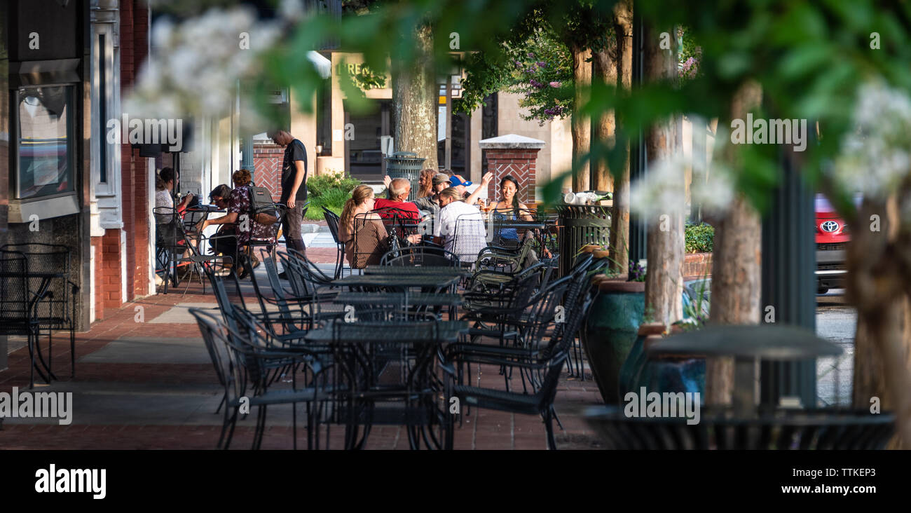 Collecte d'amis autour de tables sur le trottoir au centre-ville des traites sur la place historique de la ville de Gainesville, en Géorgie. (USA) Banque D'Images