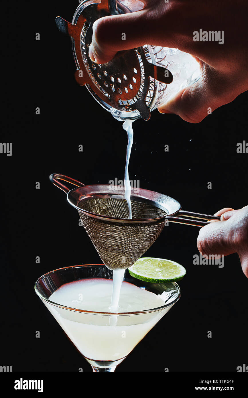 Portrait des mains préparation cocktail sur fond noir Banque D'Images